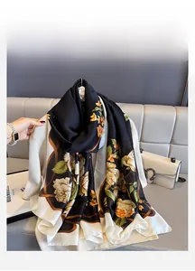 Detailed texture of lightweight silk scarf with yellow roses over a white cardigan