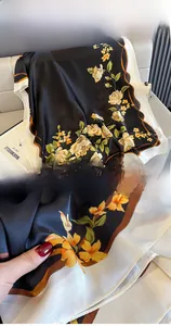 Detail of silk-like floral shawl with premium rolled edges and yellow rose patterns