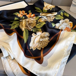 Detailed macro view of floral print satin shawl with smooth silk texture and vivid colors