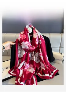 Detail of red floral silk scarf with large white flower prints and border lettering