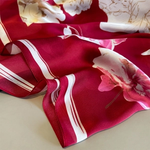Elegant deep red floral silk scarf with white and pink blossoms in draped texture