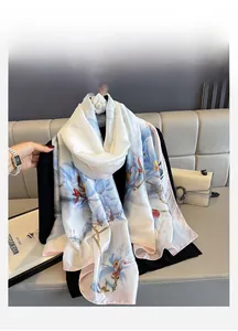Detail showing elegant magnolia floral print on light blue silk scarf with pink edges