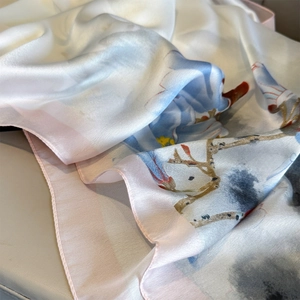 Macro shot of silk scarf detailing ink flower prints and delicate pink rolled edges