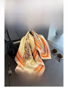 Détail d'un foulard 100% soie de mûrier à motifs floraux vintage drapé sur un sac