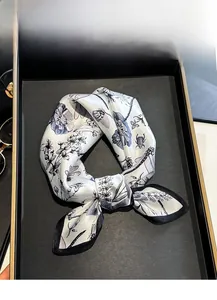 Detail of dragonfly silk scarf showing hand-painted patterns and black rolled edges