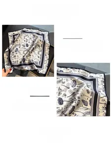Detail view of the hand-rolled edges and dragonfly floral print on silk neck scarf
