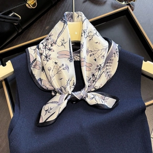Elegant dragonfly print silk scarf tied on a navy vest with a retro luxury aesthetic