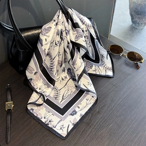 Vintage dragonfly print silk scarf tied on a leather handbag with fashion accessories