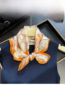 Detail of printed mulberry silk scarf styled as a necktie on a dark knit top