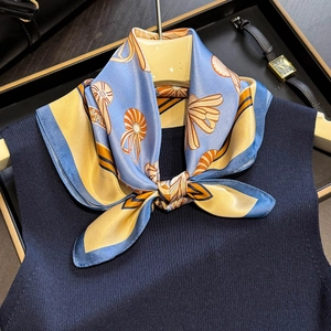Light blue silk scarf with gold seashell prints paired with a vest and watch