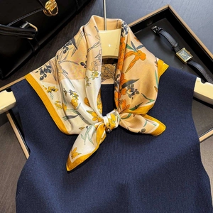 Eleganter Seidenschal mit gelbem Blumenmuster auf dunkelblauem Pullover Dekoration
