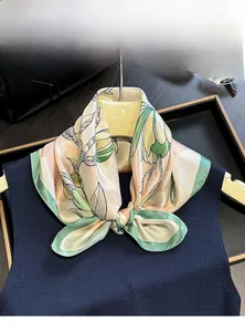 Close-up of 100% mulberry silk scarf with magnolia floral print on a model's neck