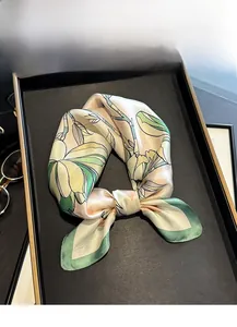 Detail of mulberry silk scarf with green magnolia print and hand-rolled edge contrast