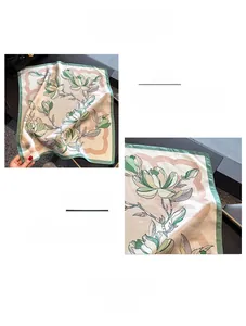 Detailed close-up of premium silk scarf with magnolia prints and green hem stitching