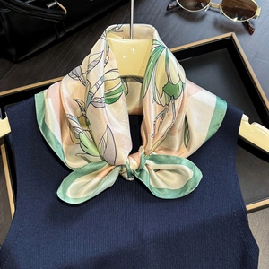 Elegant mulberry silk scarf with magnolia floral print and green border styled on a model