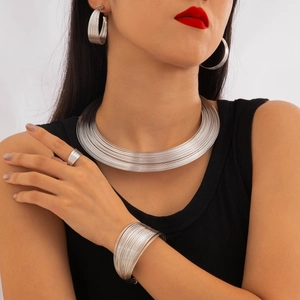 Detailed close-up of multilayer silver jewelry set on model featuring necklace and earrings