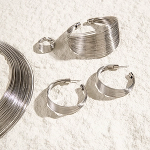 Detail shot of multi-layer silver choker set including bracelets and hoop earrings