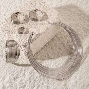 Detailed close-up of a silver multi-layer coil jewelry set including choker and earrings
