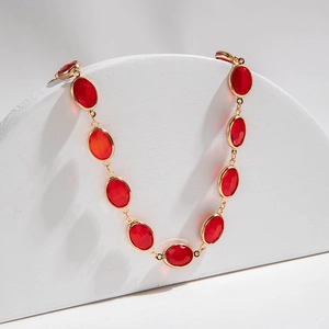 Dettaglio della collana con pietre rosse ovali e montatura dorata su espositore
