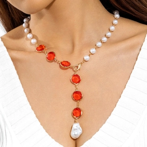 Collana a Y con perle bianche, pietre rosse e perla barocca indossata da una modella