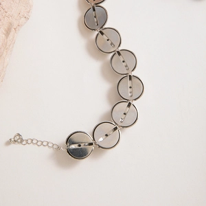 Macro detail of silver metal choker with smooth circular links and adjustable extension chain