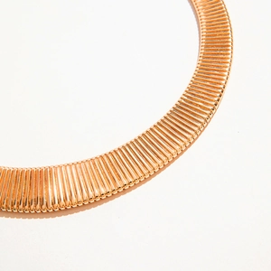 Detailed macro view of rose gold choker necklace featuring a ribbed spiral texture