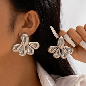 Vue détaillée de grandes boucles d'oreilles argentées avec finition miroir polie