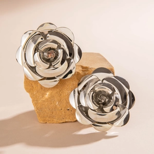 Vue détaillée de boucles d'oreilles roses en argent poli sur un fond de pierre naturelle