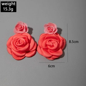 Détail des boucles d'oreilles roses en tissu 3D montrant les dimensions 8,5 cm sur 6 cm