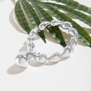 Silver comma beaded elastic bracelet with a polished liquid metal teardrop design