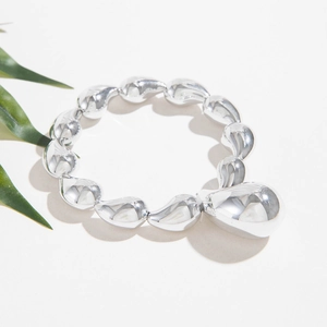 Polished silver beaded elastic bracelet featuring a large teardrop comma pendant