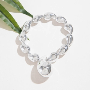 Polished silver beaded bracelet with large comma-shaped charms on white background