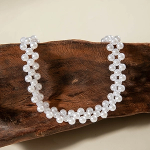 Close-up of elegant double-row imitation pearl necklace on rustic wooden stand