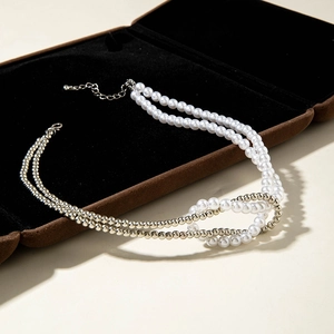 Detail of double-layer beaded necklace with pearls and metal beads on velvet jewelry box