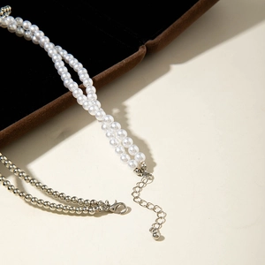 Detail of double-layer beaded necklace featuring faux pearls and silver metal beads