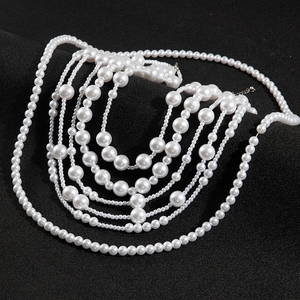 Detail of multi-layered faux pearl necklace with silver lobster clasp and extender chain