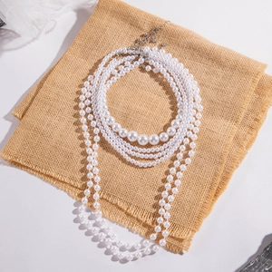 Detail of multi-layer faux pearl necklace with silver lobster clasp and extender chain