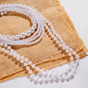 Detailed close-up of multi-layer white pearl necklace featuring elegant cream luster finish