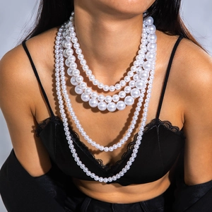 Detailed macro view of layered white faux pearl necklace with multi-strand gradient design