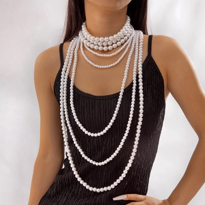 Detail of multi-layered pearl necklace with white beads on elegant black fabric