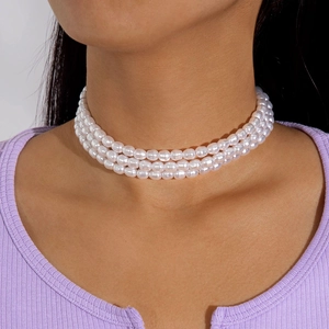 Close-up of triple-strand pearl choker necklace with white vintage beads on model