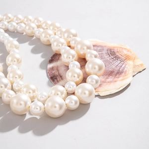 Detailed macro view of multi-sized cream white pearl necklace with natural shells