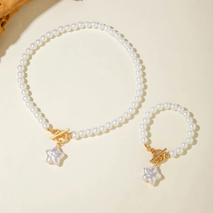 Dettaglio del set di gioielli in perle con chiusura a T dorata e ciondolo a stella