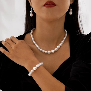 Set di gioielli di perle con collana, bracciale e orecchini su un abito di velluto nero