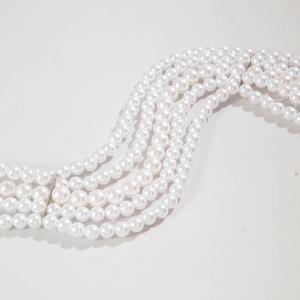 Detail of multi-layer faux pearl necklace showing five strands and metal spacer bars