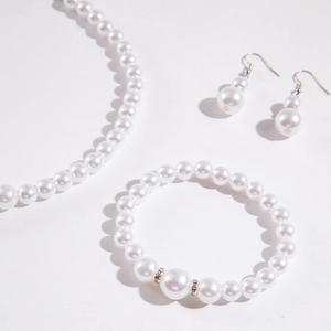 Dettaglio del set di gioielli di perle con collana, bracciale e orecchini su bianco