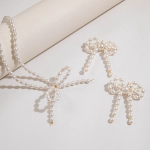 Dettaglio del set di gioielli con perle con collana e orecchini a forma di farfalla