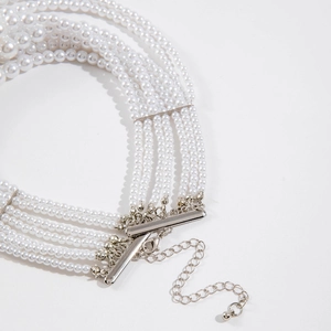 Macro detail of multi-layered pearl necklace with silver clasp and adjustable chain