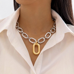 Primer plano de collar minimalista de eslabones bicolor plata y oro sobre una modelo
