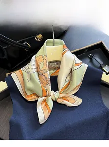 Detail of 100% mulberry silk scarf with floral patterns on a dark blue knit sweater
